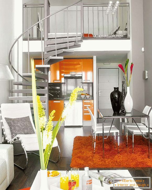 Wnętrze mieszkania z spiralnymi schodami na drugi poziom nad kuchnią
