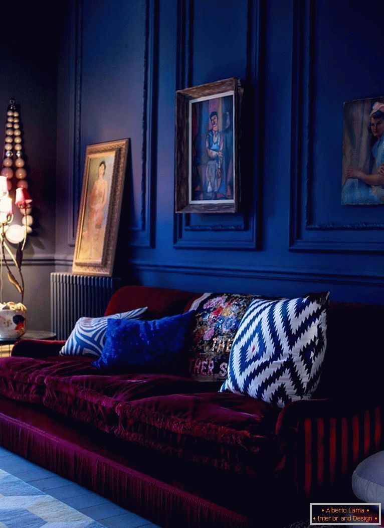 Bordowa sofa na tle ciemnoniebieskich ścian