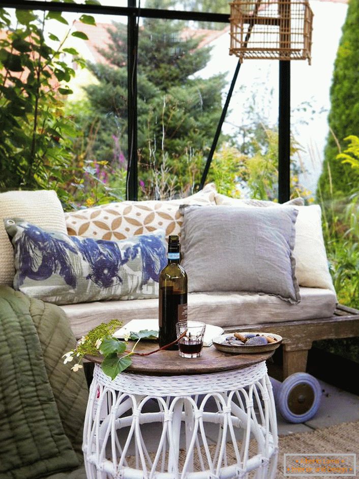 Najlepszym wystrojem altanki w skandynawskim stylu jest sofa z dużą ilością miękkich poduszek.