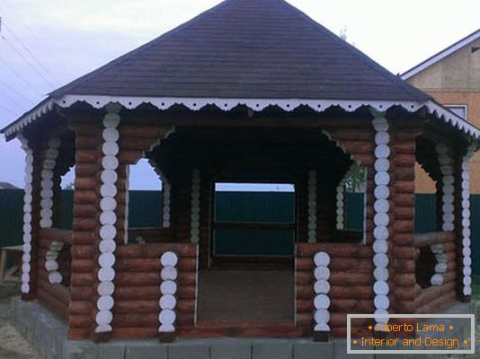 Struktura domu z bali jest klasyczną opcją dekoracji dziedzińca dworu wiejskiego.