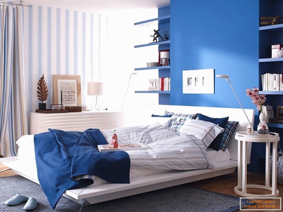Niebieska ściana w sypialni połączona z pasiastą tapetą