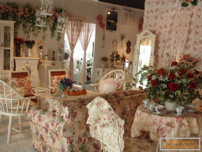 Kwiaty w wazonie, na ścianie, a nawet na tapicerce sofy. Hall w stylu Prowansji w małym wiejskim domu na południu Francji.