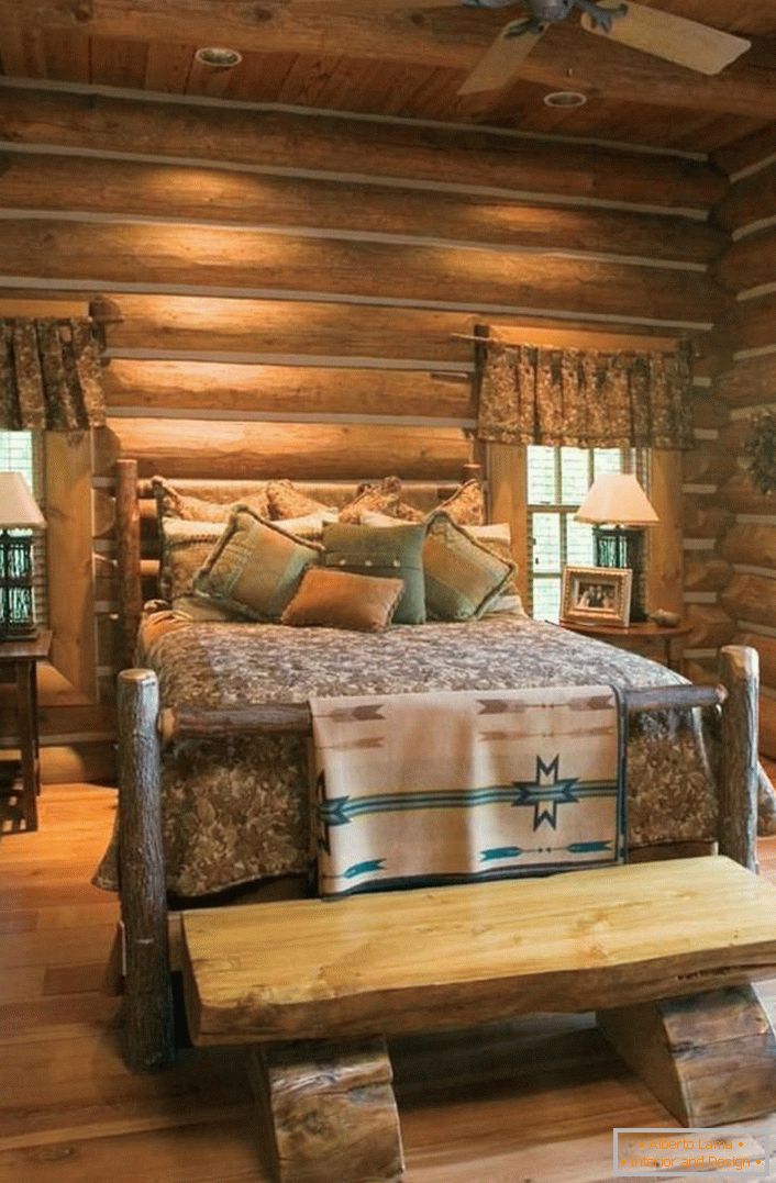 Klasyczny przykład sypialni w stylu rustykalnym. Ciekawe łóżko z surowego, nieobrobionego domu z bali. 
