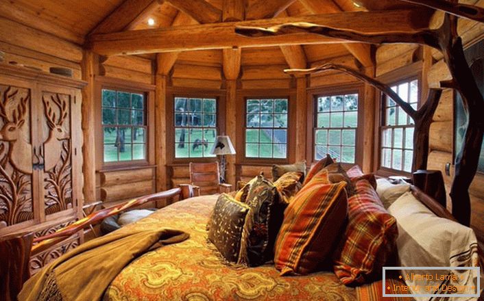 Jedna z sypialni w domu nad jeziorem wykonana jest w stylu wiejskiego kraju. Drewniana dekoracja. Masywne meble i elementy wystroju są wyselekcjonowane w najlepszych tradycjach stylu.