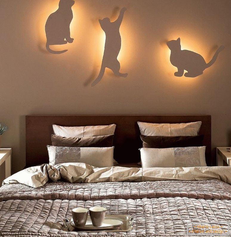 Koty z lampkami na ścianie