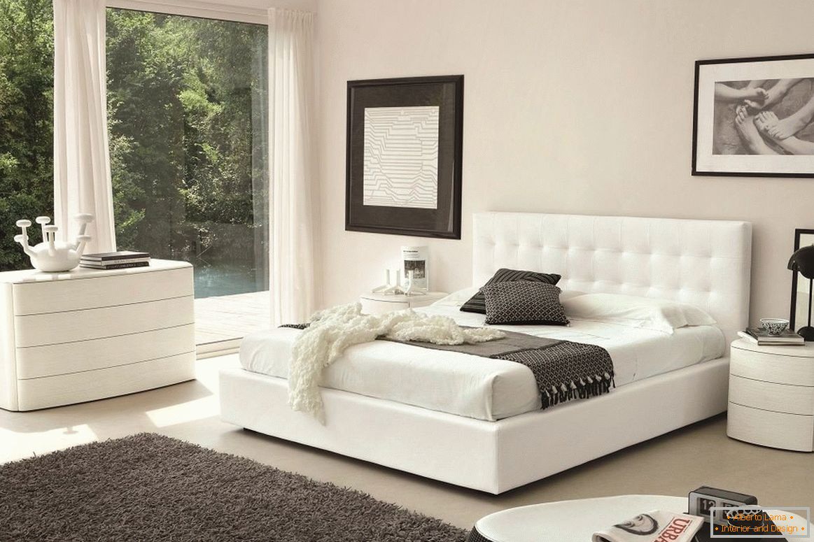 Białe łóżko, komoda i stolik nocny w sypialni
