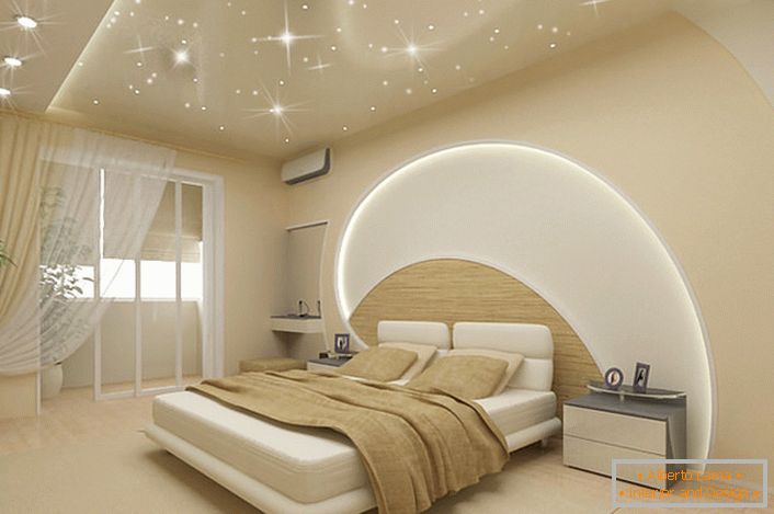 Uwagę przyciąga dekoracja ścian i sufitu w sypialni w nowoczesnym stylu. Paski LED przechodzą przez sufit i ścianę nad łóżkiem, sufity napinane naśladują magiczne gwiaździste niebo.