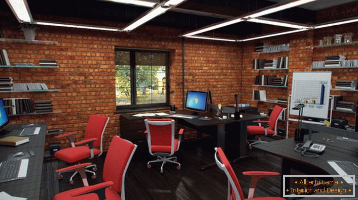 Czerwone krzesła w biurze w stylu loftu wyglądają organicznie i kreatywnie. Wnętrze jest tak funkcjonalne, jak to tylko możliwe.