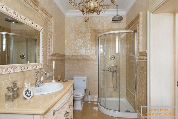 Łazienka jest urządzona w stylu neoklasycystycznym. Duże lustro, otoczone szeroką ramą, sprawia, że ​​zdjęcie jest kompletne.