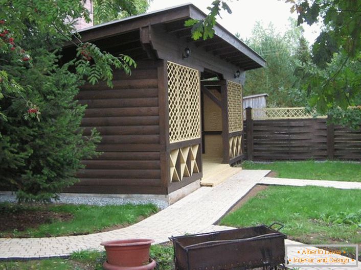 Ciemna altana wykonana z drewna w stylu chaty jest popularnym wyborem dla współczesnych właścicieli podmiejskich nieruchomości.