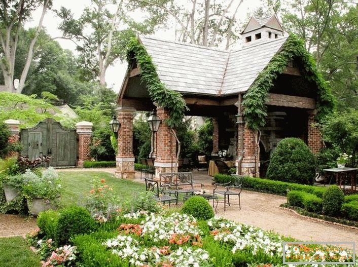 Elegancka prostota otwartej altany w stylu domku wygląda organicznie w luksusowym, przytulnym ogrodzie. 