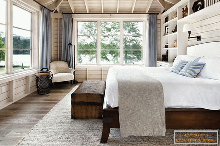 Sypialnia w skandynawskim stylu z dużym podwójnym łóżkiem z drewna w domu francuskiego biznesmena.