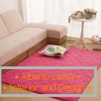 Różowy dywan w pobliżu białej sofy