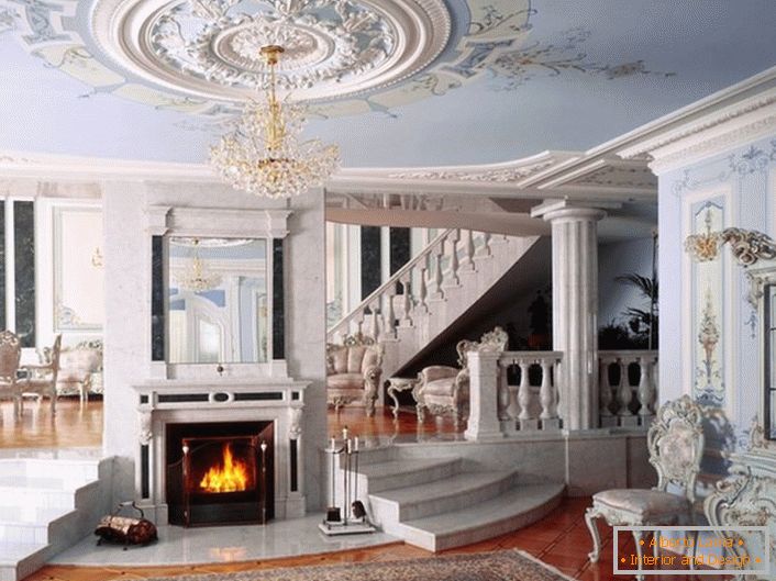 Sala z kominkiem w stylu neoklasycznym wyróżnia się kolorystyką wybraną do dekoracji. Delikatny błękitny i biały odcień harmonijnie połączone w jedną kompozycję.