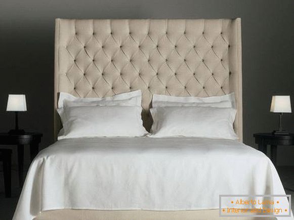 Podwójne łóżko z wysokim miękkim beżowym zagłówkiem