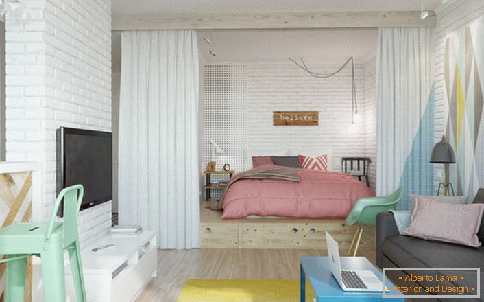Skandynawski styl jest idealny, jeśli mówimy o projekcie małego mieszkania. W niszy znajduje się sypialnia z dużym miękkim łóżkiem.