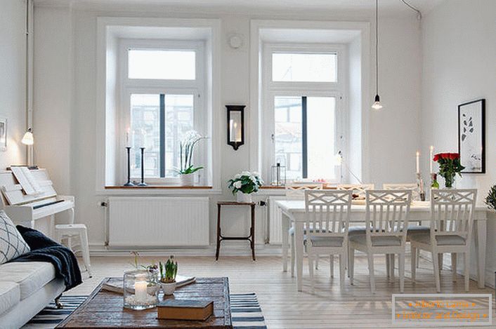 Stylowy salon podzielony jest na część wypoczynkową i jadalnię. Zgodnie ze stylem skandynawskim ściany pokoju są urządzone w kolorze białym.