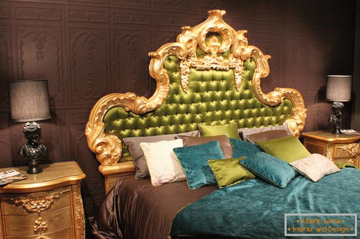 Głównym elementem, który przyciąga wzrok, jest wysoki tył łóżka, ubrany w jedwabny zielony kolor, w złotej rzeźbionej ramie.