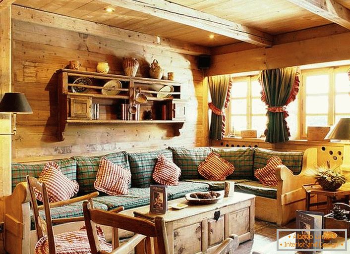 Drewniana dekoracja ścienna, kontrastujące poduszki na miękkiej sofie, gęste zasłony z marszczeniami w oknach. Przytulny salon w stylu rustykalnym w wiejskim domu.