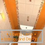 Połączenie białej i pomarańczowej płytki w projektowaniu toalety