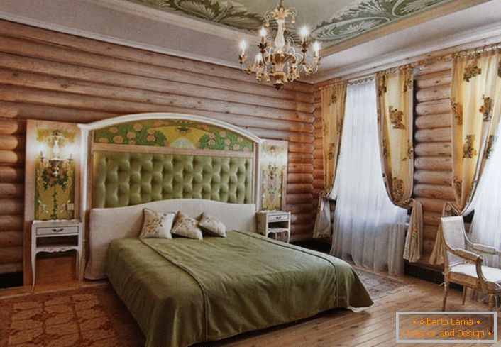 Ściany sypialni w najlepszych tradycjach kraju zdobią naturalne drewniane bali. Jednak bez motywów kwiatowych wciąż donikąd. Jasnobeżowe zasłony zdobią rzadki kwiatowy wzór.