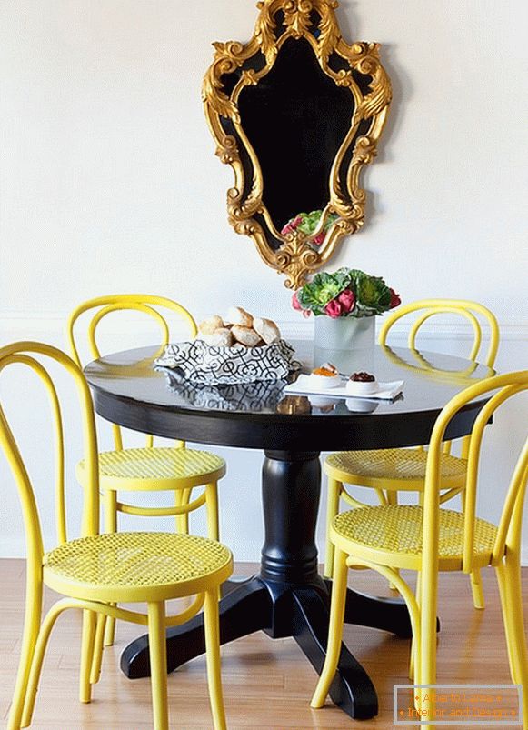 Jasne żółte krzesła i czarny stół jadalny
