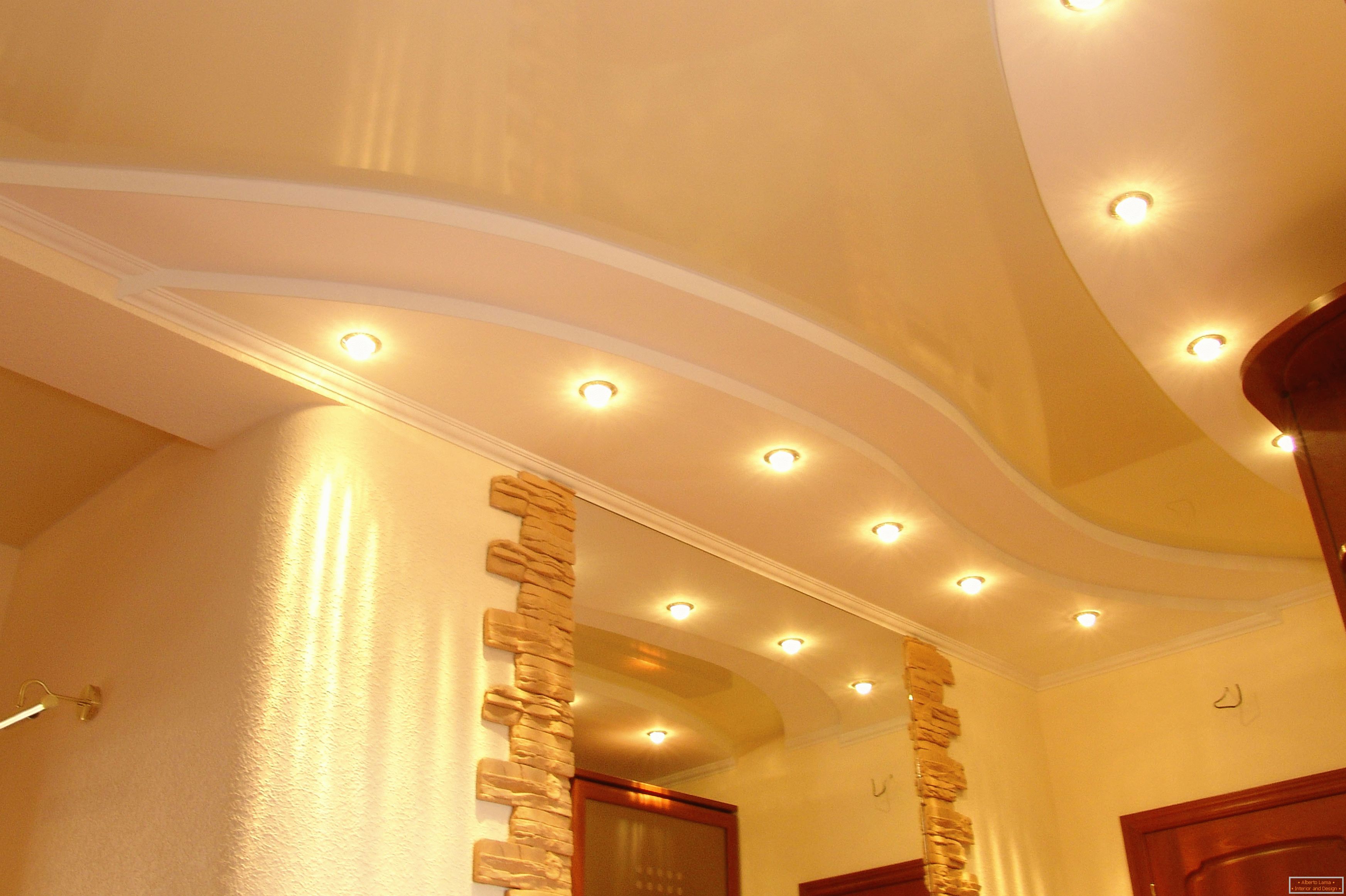Poprawnie urządzony sufit w korytarzu. Oświetlenie punktowe - najbardziej odpowiednia opcja dla sufitów napinanych PVC.