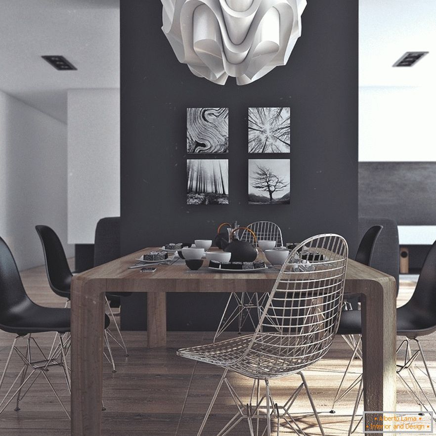 Drewniany stół, czarne krzesła i oryginalne obrazy na czarnej ścianie