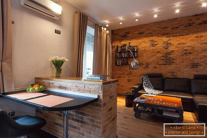 Ściana w salonie jest urządzona w stylu loftu. Murowanie jest jednym z najpopularniejszych elementów.
