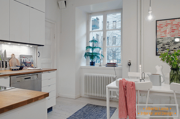 Kuchnia z jadalnią w małym mieszkaniu w stylu skandynawskim