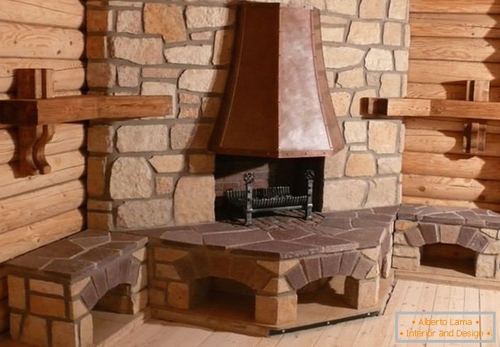 Prawdziwy kominek narożny z kominem w stylu skandynawskim. Naprzeciw portalu z kamienia naturalnego pozwoli długo utrzymać ciepło w domku z bali.