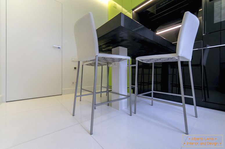 Białe krzesła na tle kuchni czarnej i zielonej