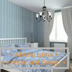 Niebieska sypialnia z białymi zasłonami