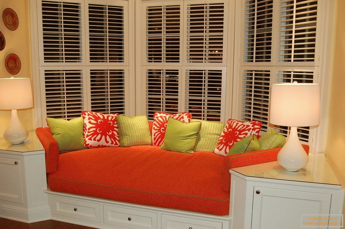 Czerwona kanapa z kolorowymi poduszkami