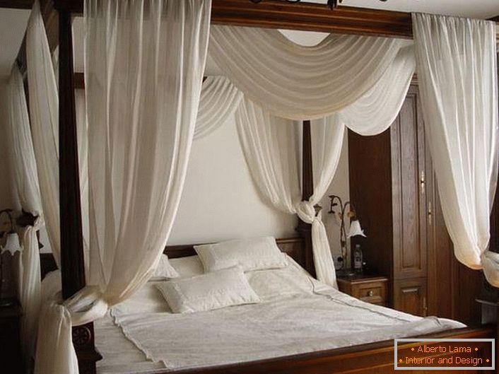 Biały baldachim nad prostym, lakonicznym łóżkiem z drewna.