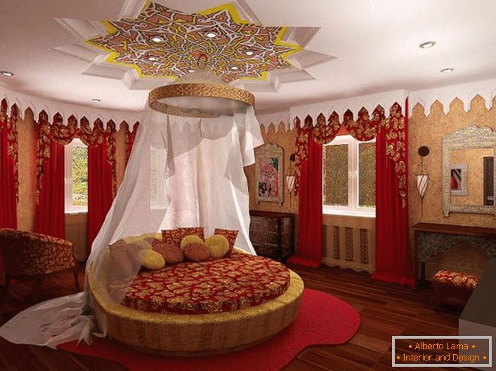 Pośrodku kompozycji znajduje się okrągłe łóżko pod baldachimem. Uwaga przyciąga sufit, który jest ciekawie ozdobiony nad łóżkiem.
