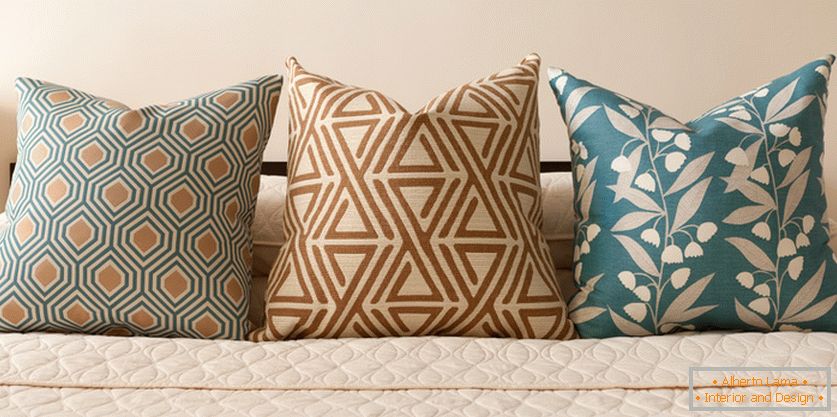 Dekoracyjne poduszki na łóżku w pastelowych kolorach turkusu