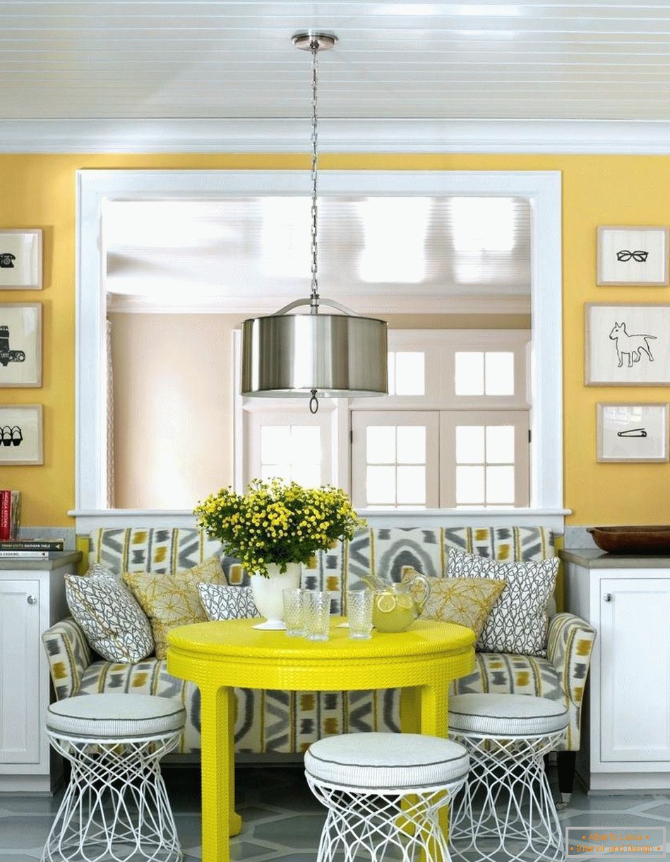 Białe krzesła wokół żółtego stołu