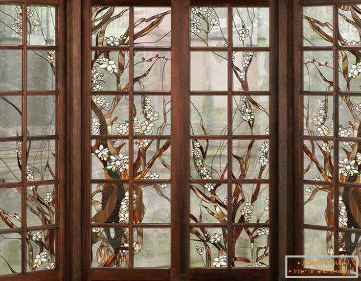 Okna w ciemnej drewnianej ramie zdobione są witrażami. Nieskomplikowana figura nadająca się do aranżacji wnętrz w stylu country lub nowoczesnym.