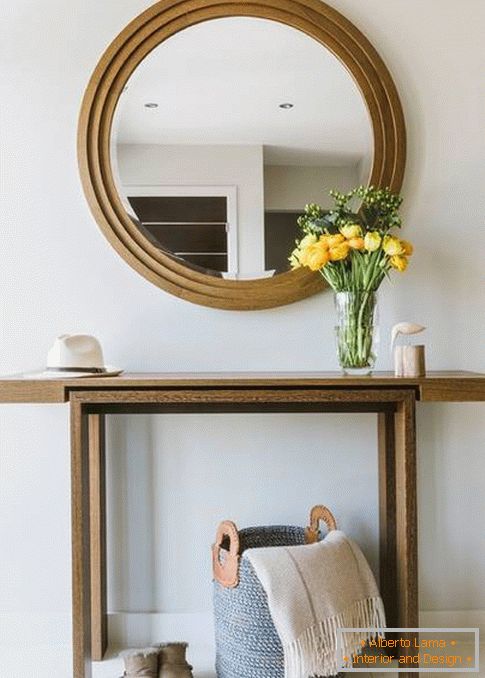 Okrągłe lustro w korytarzu z drewnianym wykończeniem