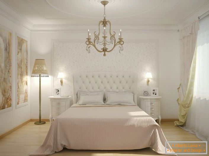 W centrum sypialni znajduje się łóżko z wysokim tapicerowanym zagłówkiem z tkaniny. Miękka, pikowana tapicerka sprawia, że ​​atmosfera jest szlachetna i stylowa.