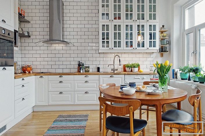 Wnętrze kuchni wykonane jest w stylu skandynawskim, który wyraża się w białym, spokojnym designie. 