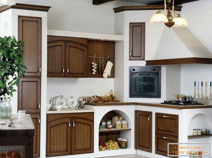 Korzystne połączenie białego i ciemnego drewna w kuchni w wiejskim stylu. Kuchenka z kapturem wygląda jak kuchenka z bajek, którą nasi rodzice czytali nam w dzieciństwie.
