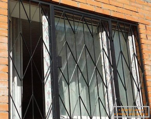 Metalowe kraty wahadłowe w oknach parteru