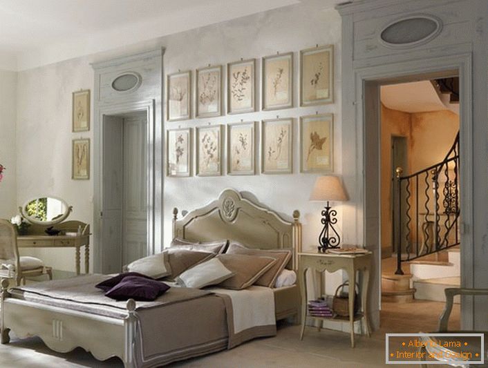 Zgodnie z tradycjami francuskiego stylu do sypialni wybrano lakoniczne lekkie meble z drewna. Ciekawym detalem jest kolaż zdjęć nad wezgłowiem łóżka.