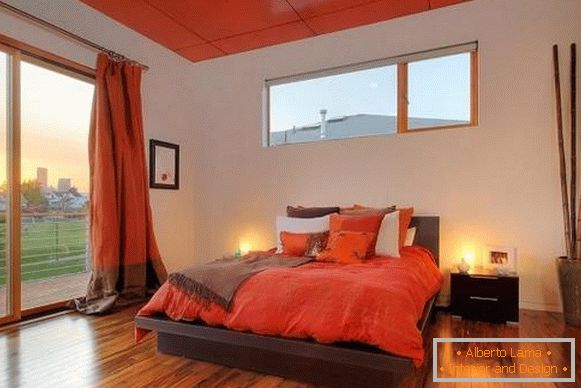 Jaskrawe czerwone zasłony we wnętrzu sypialni - fotografia