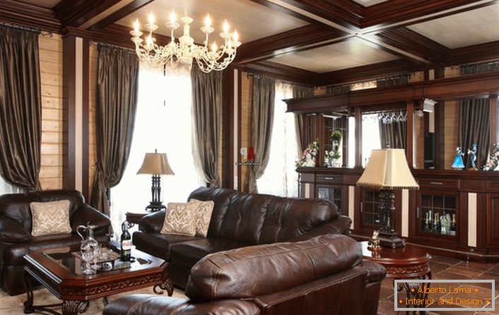Elegancki pokój gościnny z blatem barowym. Uwaga przyciąga ogromne meble tapicerowane, skórowane. 