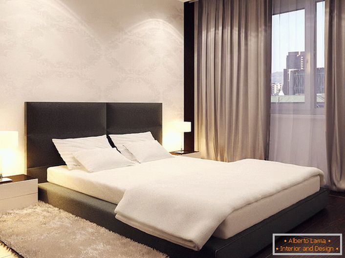 Łóżko w minimalistycznym stylu przypomina niskie podium. Wysoki, miękki zagłówek sprawia, że ​​konstrukcja jest bardziej miękka i gładka.